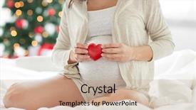  Presentation with christmas holidays - Theme having pregnancy holidays love people and expectation concept - close up of pregnant woman with red heart in bed over christmas tree background background and a coral colored foreground