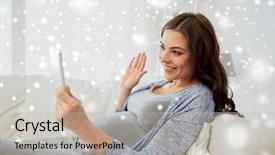  Presentation with winter video - Amazing theme having pregnancy winter technology people and communication concept - happy pregnant woman with tablet pc computer having video call and waving hand at home over snow backdrop and a soft green colored foreground
