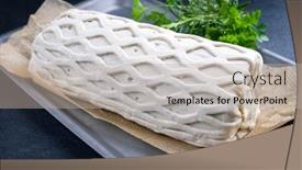  Presentation with puff pastry - Presentation theme consisting of raw kasseler pork steak as piece in puff pastry as closeup offered on a griddle with herbs background and a mint green colored foreground