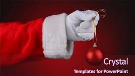  Presentation with sparkly - Presentation theme consisting of santa claus hand holding a sparkly red ornament on a gold ribbon over a light to dark red background horizontal format hand and arm only background and a tawny brown colored foreground