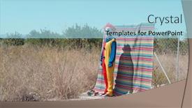  Presentation with red blue yellow - Presentation with scary clown in a colorful yellow red and blue costume standing in front of a fence with a colorful striped piece of cloth hanging from it and an abandoned natural landscape in the background background and a light blue colored foreground