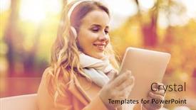  Presentation with computer music - Theme featuring season technology and people concept - beautiful happy young woman with tablet pc computer and headphones listening to music and sitting on bench in autumn park background and a coral colored foreground