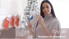  Presentation with look - PPT theme with smiling attractive trendy young woman opening a christmas present in her living room picking at the ribbon with a look of joyful anticipation background and a gray colored foreground