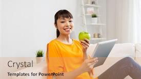  Presentation with green technology - Slides with technology education diet and people concept - happy young asian woman sitting on sofa with tablet pc computer and green apple at home background and a coral colored foreground