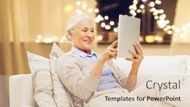  Presentation with old age - Audience pleasing theme consisting of technology old age and holidays concept - happy senior woman with tablet pc computer at home over garland lights background backdrop and a lemonade colored foreground