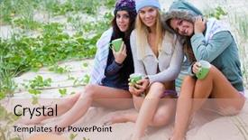  Presentation with huddle - Beautiful slides featuring three attractive young women in swimsuits huddle together on the beach they are wearing upper body clothing for warmth horizontal shot backdrop and a coral colored foreground