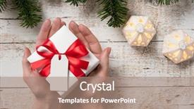  Presentation with gift ribbon - Cool new presentation theme with top view of female hand holding white christmas gift box wrapped with red ribbon high angle view of woman showing xmas present on rustic wooden table with fir branch on top backdrop and a coral colored foreground