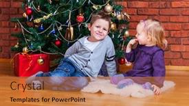  Presentation with christmas kids - PPT theme consisting of two small kids at home sitting near beautifully decorated christmas tree background and a gold colored foreground