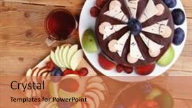  Presentation with tea cake - Presentation theme featuring whole big chocolate cream brownie cake topped with white chocolate and cream flowers with hot tea cup decorated with fruits apple plum and grape on plate on wooden table background and a coral colored foreground