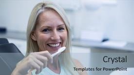  Presentation with tooth brush - PPT theme having woman holding tooth brush in dental clinic background and a light blue colored foreground