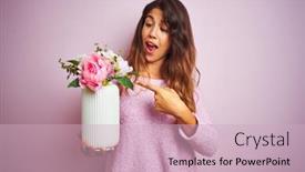  Presentation with hand holding flowers - Presentation theme consisting of young beautiful woman holding a pot of flowers over pink isolated background very happy pointing with hand and finger background and a soft green colored foreground