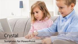  Presentation with young children - Amazing PPT theme having young children sitting on couch at home using laptop computer girl looking at screen with serious expression boy smiling backdrop and a mint green colored foreground