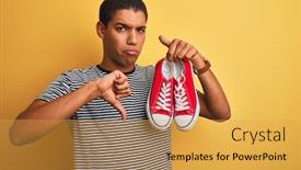  Presentation with sneakers - Theme having young handsome arab man holding casual sneakers standing over isolated yellow background with angry face negative sign showing dislike with thumbs down rejection concept background and a yellow colored foreground