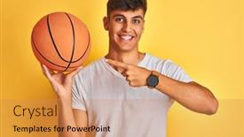  Presentation with basketball - Beautiful presentation theme featuring young indian sportsman holding basketball ball standing over isolated yellow background very happy pointing with hand and finger backdrop and a coral colored foreground