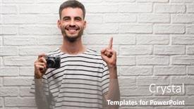  Presentation with white brick - Slides enhanced with young man holding vintage camera standing over white brick wall surprised with an idea or question pointing finger with happy face number one background and a gray colored foreground