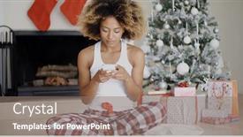  Presentation with text message - Theme with young woman sending a christmas text message on her mobile phone as she sits on the floor in front of the decorated hearth and xmas tree background and a gray colored foreground