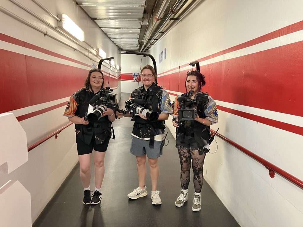 group of three students with cameras