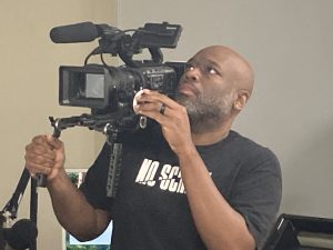 person with camera on shoulder
