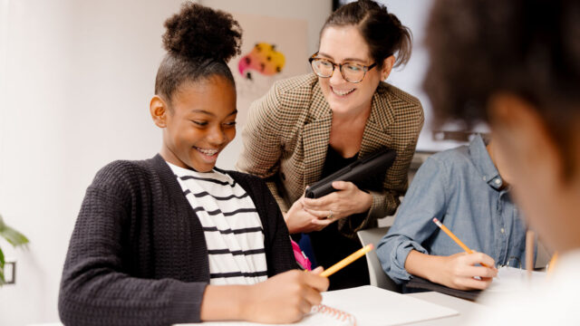 Teacher with students in middle school classroom