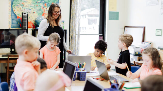Educator supports students during structured literacy classroom instruction