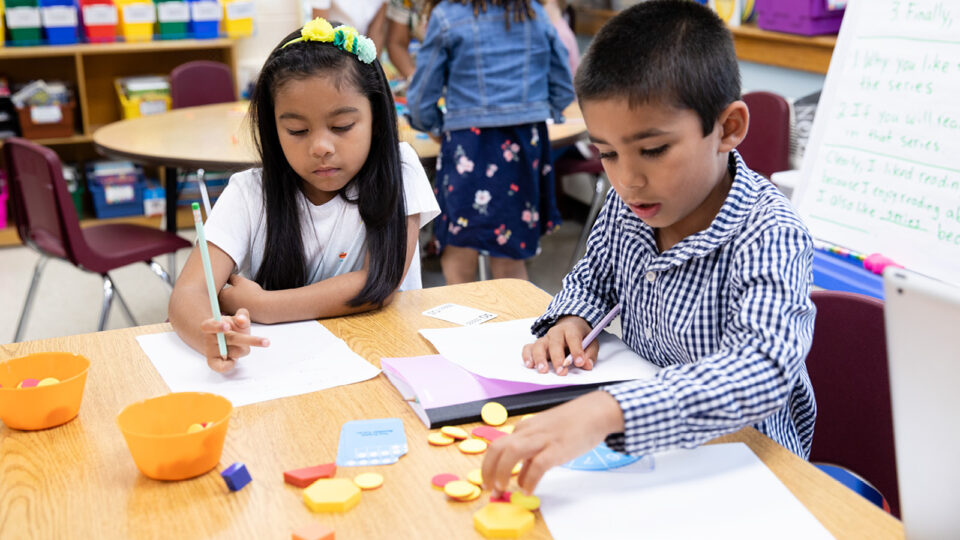 Two children in the classroom counting