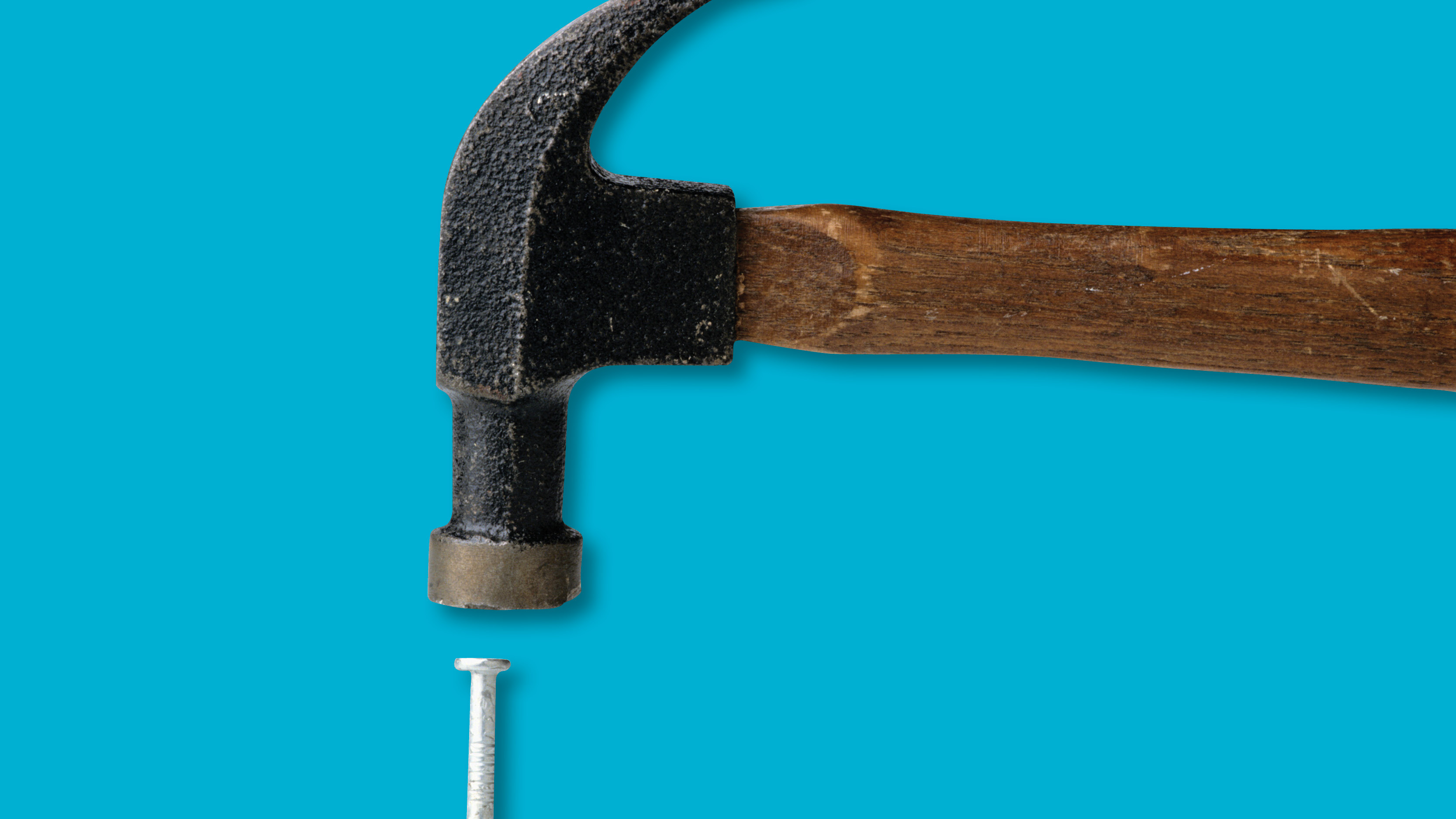 Hammer and nail against blue background