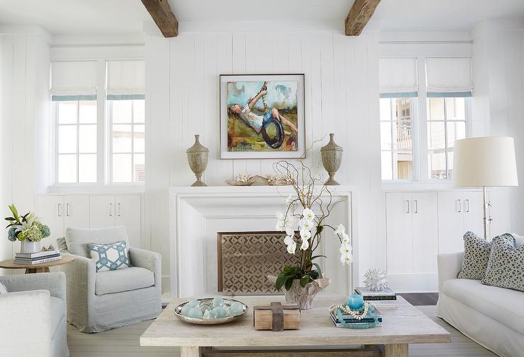 beach-style-living-room-white-beveled-firpelace-with-gray-wood-urns.jpg