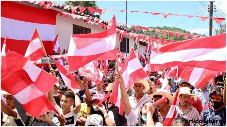 Simpatizantes del Partido Liberal sostienen la bandera que representa su partido político.