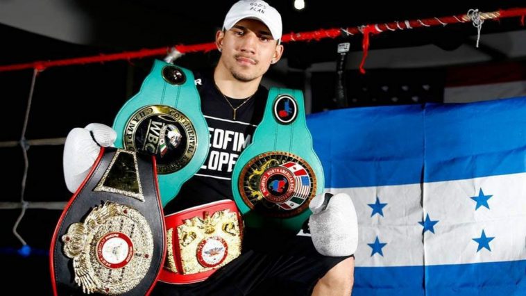 Teófimo López posa junto a sus títulos de la AMB, FIB y OMB de boxeo