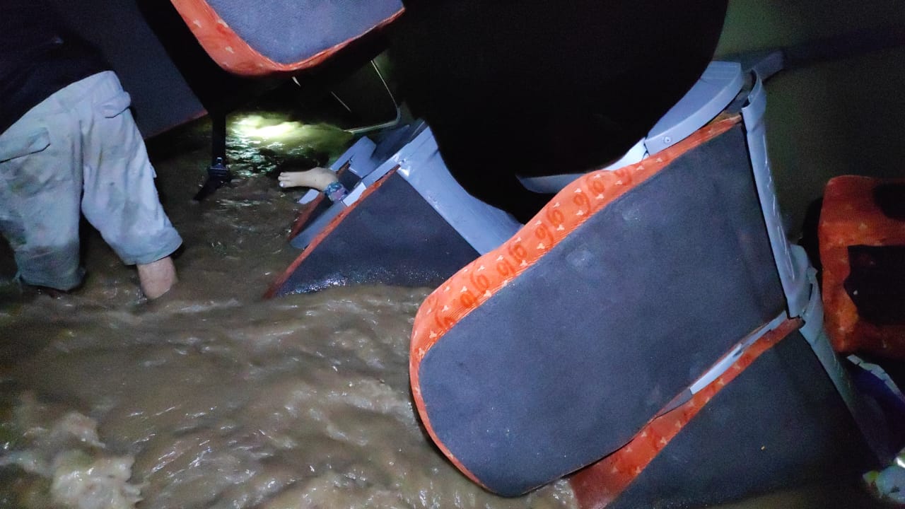 En esta imagen se puede observar el cadáver de la mujer migrante que quedó atrapada entre los asientos del bus que se precipitó al río.