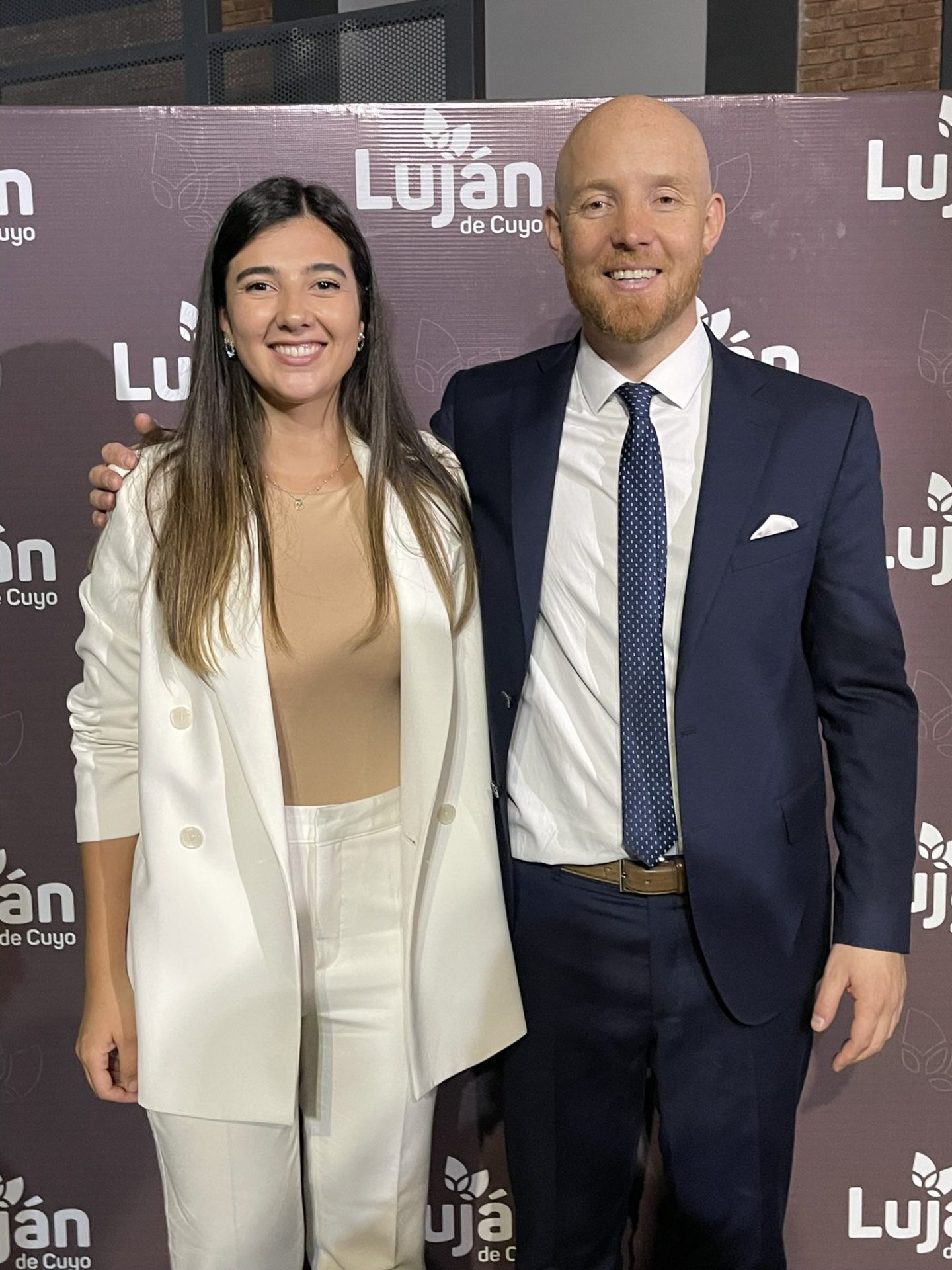 Julieta Reyes in a white suit and a brown shirt