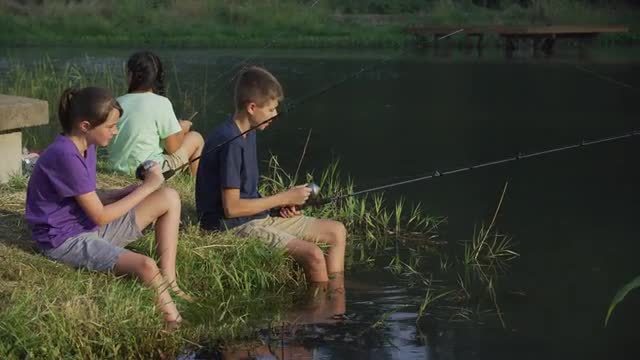 Kids at summer camp fishing in pond