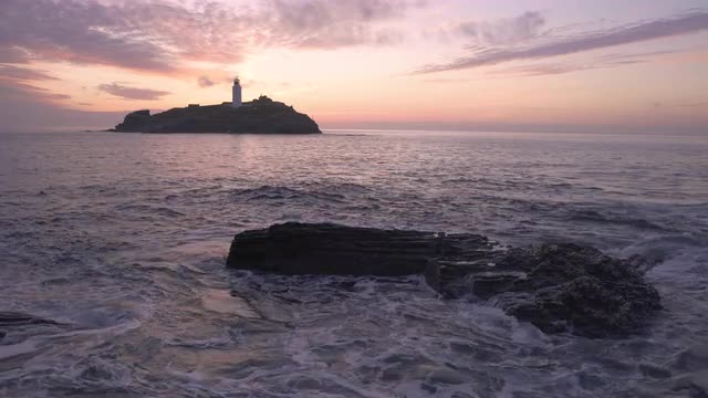 Beautiful sunset waves rocks at Godrevy Lighthouse, Cornwall, UK