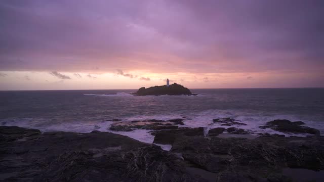 Beautiful sunset waves rocks at Godrevy Lighthouse, Cornwall, UK