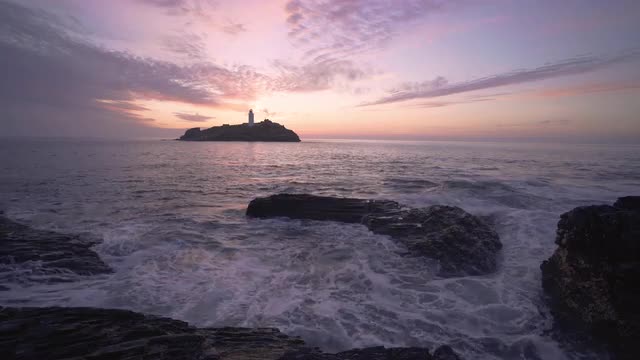 Beautiful sunset waves rocks at Godrevy Lighthouse, Cornwall, UK