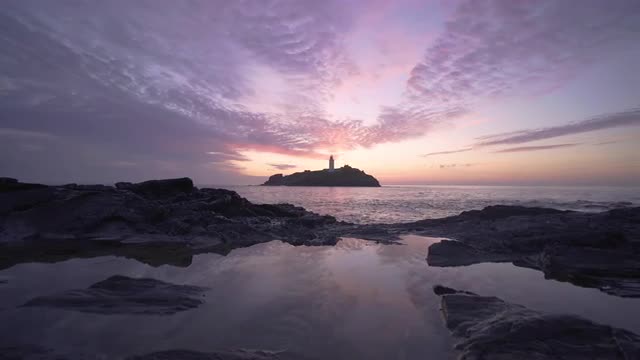 Beautiful sunset waves rocks at Godrevy Lighthouse, Cornwall, UK