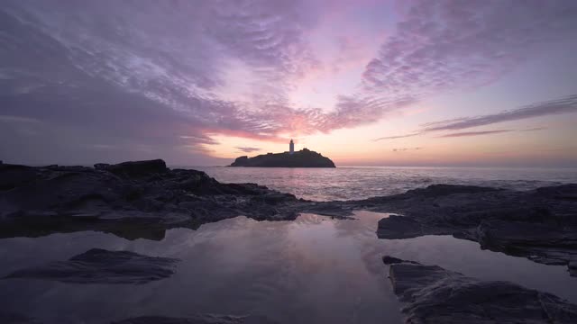 Beautiful sunset waves rocks at Godrevy Lighthouse, Cornwall, UK