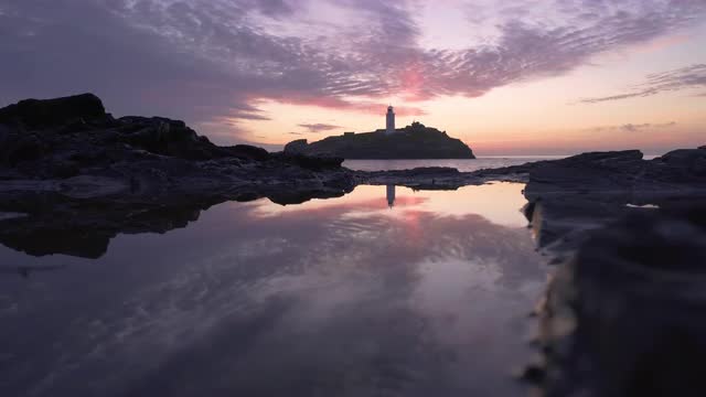 Beautiful sunset waves rocks at Godrevy Lighthouse, Cornwall, UK