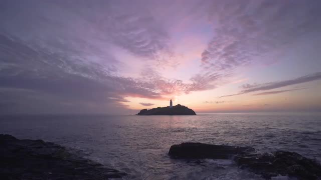 Beautiful sunset waves rocks at Godrevy Lighthouse, Cornwall, UK