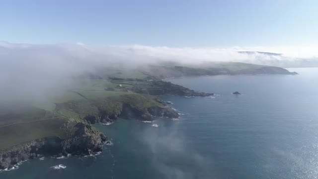 Aerial View Of Fog Mist Over Seaside Cliffs in Cornwall, England, UK 4K