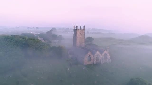 4K Aerial footage of a church in England covered by thick fog