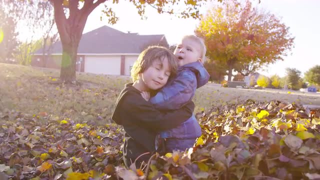 5 year old boy tries to comfort grumpy toddler, who pushes him away