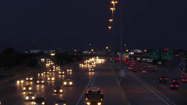 View of traffic on freeway with storm above and lightning strikes