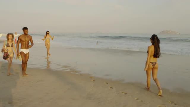 RIO DE JANEIRO-JUNE 16: Young people walk along the beach on June 16, 2013 in Rio de Janeiro. RIO DE JANEIRO-JUNE 16: Young people walk along the beach on June 16, 2013 in Rio de Janeiro.