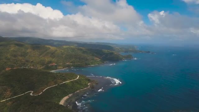 Seascape with tropical island, rocks and waves. Catanduanes, Philippines.