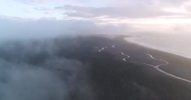 An aerial view through clouds towards the West Coast at Gillespie Beach. New Zealand.
