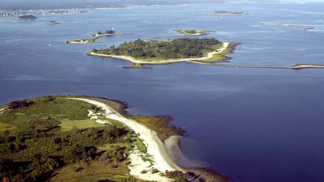 WIDE AERIAL POV over small mostly uninhabited islands