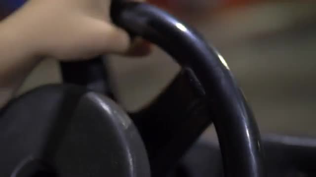 Child driving car on the attraction at fun fair