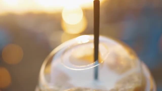 Takeaway cold coffee drink in sunset light