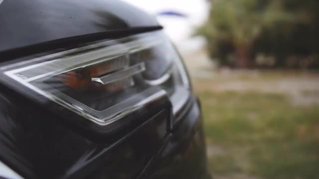 Headlight of modern black car. Detailed view on lighting gear. Close up shot